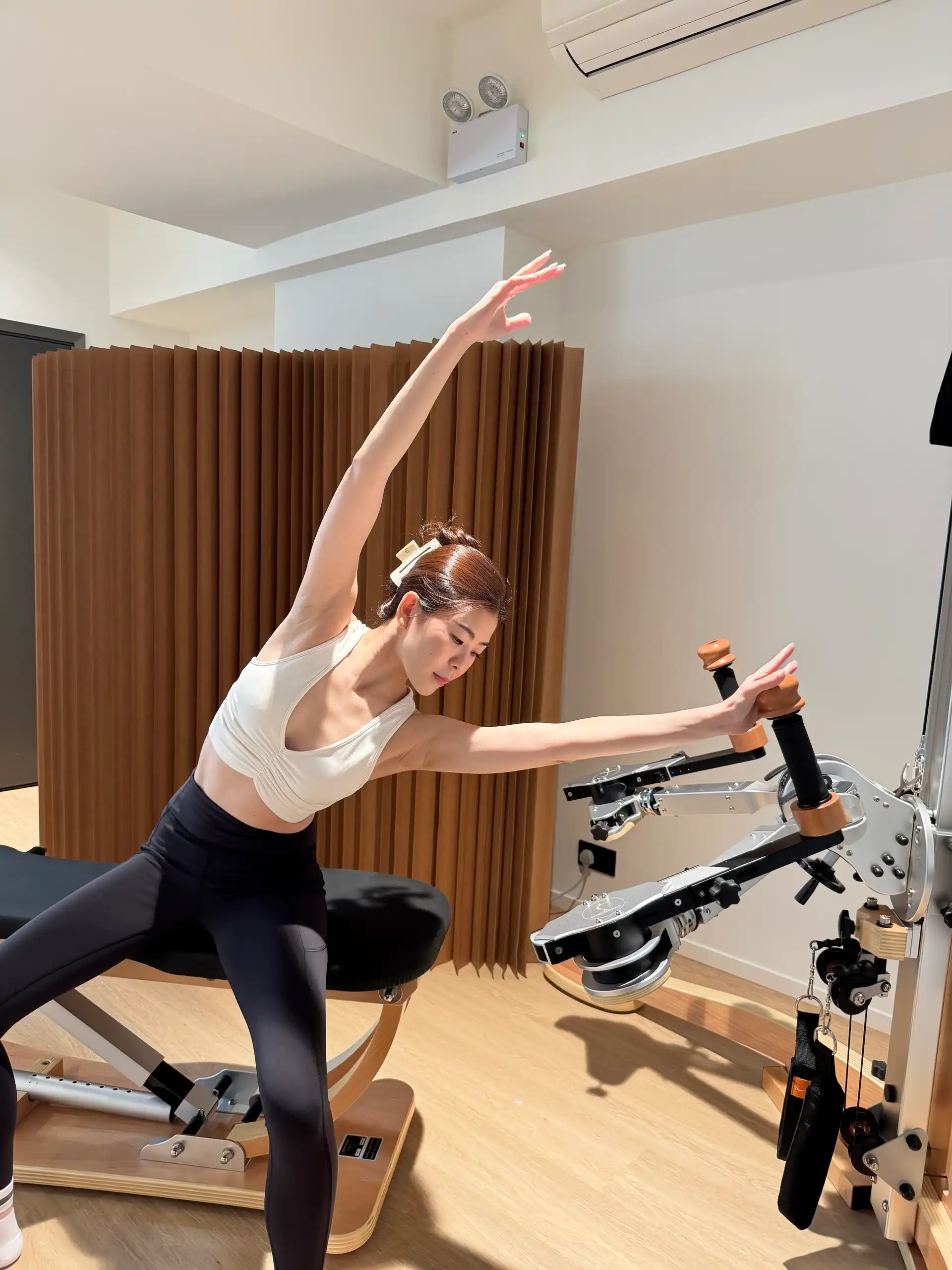 Private Pilates training session with a side stretch on the reformer at Relevé Studio Sheung Wan